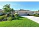 Charming home featuring a well-manicured lawn, colorful flowerbeds, and a convenient two-car garage at 5283 Chase Oaks Dr, Sarasota, FL 34241