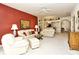 Bright living room with white sofas, ceiling fan, and a decorative red accent wall at 5283 Chase Oaks Dr, Sarasota, FL 34241
