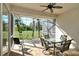 An enclosed lanai with a ceiling fan features comfortable seating and a peaceful view of the golf course at 5283 Chase Oaks Dr, Sarasota, FL 34241