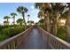 Picturesque boardwalk surrounded by tropical foliage leading to the beach at 535 Sanctuary Dr # A202, Longboat Key, FL 34228