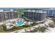 Luxury condos with outdoor pool, lounge areas, and beach access, surrounded by palm trees at 535 Sanctuary Dr # A202, Longboat Key, FL 34228