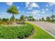 Scenic view of the Lakewood National entrance with a stone water feature, palm trees, and well-manicured landscaping at 5537 Palmer Cir # 205, Lakewood Ranch, FL 34211