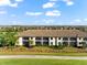 Exterior view of a condo building with a tile roof, screened lanais and landscaping at 5537 Palmer Cir # 205, Lakewood Ranch, FL 34211