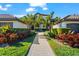 Beautifully landscaped villa with palm trees and a brick pathway leading to the entrance at 5537 Palmer Cir # 205, Lakewood Ranch, FL 34211