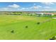 Expansive golf course with golfers practicing, featuring a blue sky, green fairways, and a tranquil water hazard at 5537 Palmer Cir # 205, Lakewood Ranch, FL 34211