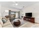 This living room boasts a flatscreen TV, ceiling fan, and sliding glass door to the outdoor patio at 5537 Palmer Cir # 205, Lakewood Ranch, FL 34211