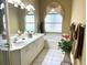 Bright bathroom with a large tub, double sinks, and decorative window treatments at 5712 Cottonwood St, Bradenton, FL 34203