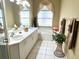 Bright bathroom featuring dual sinks, soaking tub, and tile flooring at 5712 Cottonwood St, Bradenton, FL 34203