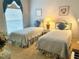 Charming bedroom with twin beds, soft blue accents, and natural light from the window at 5712 Cottonwood St, Bradenton, FL 34203