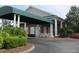 Elegant clubhouse entrance with covered portico, beautiful landscaping, and convenient circular driveway at 5712 Cottonwood St, Bradenton, FL 34203