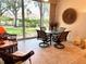 Bright sunroom with tile flooring, a table and chairs, and view of the green yard at 5712 Cottonwood St, Bradenton, FL 34203