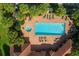 Aerial view of the community pool and patio area with lounge chairs and a spa at 574 Crane Prairie Way, Osprey, FL 34229