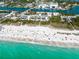 Breathtaking aerial view of the beach, filled with people enjoying the sand and surf at 5852 Ocean Isle Dr, Nokomis, FL 34275