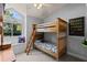 Bedroom with bunkbeds, window seat, and large window overlooking the yard at 604 68Th Avenue W Dr, Bradenton, FL 34207