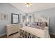 Bright bedroom featuring a large bed, white dresser, and a ceiling fan at 604 68Th Avenue W Dr, Bradenton, FL 34207