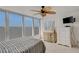 Bright bedroom features a ceiling fan, large windows, and white tile flooring at 7000 Beach Plz # 905, St Pete Beach, FL 33706