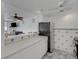Kitchen open to living space with white cabinets and stainless steel refrigerator at 7000 Beach Plz # 905, St Pete Beach, FL 33706