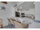 Kitchen bar that opens up into the main kitchen with white cabinetry and appliances at 7000 Beach Plz # 905, St Pete Beach, FL 33706