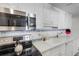 Updated kitchen featuring stainless steel microwave, white cabinetry, and white countertops at 7000 Beach Plz # 905, St Pete Beach, FL 33706