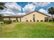Beautiful backyard with green lawn and mature landscaping surrounding the home's exterior at 7123 Heron Dr, Sarasota, FL 34243