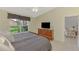 Well-lit bedroom featuring a bed, dresser, and a sunny window overlooking the lawn at 7123 Heron Dr, Sarasota, FL 34243