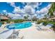 Inviting community pool surrounded by palm trees and comfortable lounge chairs for residents to enjoy at 7123 Heron Dr, Sarasota, FL 34243