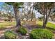 Woodlake community sign surrounded by lush landscaping and trees on a sunny day at 7123 Heron Dr, Sarasota, FL 34243