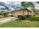 Charming home featuring a two-car garage, manicured lawn, and mature tropical landscaping at 7123 Heron Dr, Sarasota, FL 34243