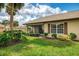 View of home with a screened-in lanai and landscaped garden, creating a serene outdoor living space at 7123 Heron Dr, Sarasota, FL 34243