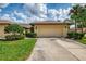 Well-maintained home exterior featuring a two-car garage, neatly landscaped yard, and paved driveway at 7123 Heron Dr, Sarasota, FL 34243