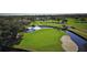 Stunning aerial view of the pristine golf course with a scenic pond and fountain at 7123 Heron Dr, Sarasota, FL 34243