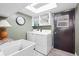 Well-equipped laundry room with washer, dryer, sink and storage shelves at 7807 24Th W Ave, Bradenton, FL 34209