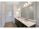 Bathroom with double vanity, modern lighting, and wood-look tile flooring at 9028 Sunray Cv, Parrish, FL 34219