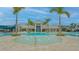 Beautiful community pool area with fountains, palm trees, and a stunning clubhouse in the background at 9028 Sunray Cv, Parrish, FL 34219