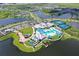Aerial view of the community clubhouse and pool, complete with tennis courts and well-manicured landscaping at 9028 Sunray Cv, Parrish, FL 34219