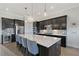Well-equipped kitchen with dark cabinets, stainless steel appliances, a wine rack, tile backsplash, and a large island at 9028 Sunray Cv, Parrish, FL 34219