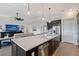 Open concept kitchen with a large island, stainless steel appliances, dark cabinets, and views to the living room at 9028 Sunray Cv, Parrish, FL 34219