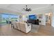 Spacious living room featuring a large ceiling fan, wood floors, and a view of the lake at 9028 Sunray Cv, Parrish, FL 34219