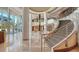 Spacious lobby featuring elegant columns, marble floors, and a grand staircase with stainless steel railings at 990 Blvd Of The Arts # 1203, Sarasota, FL 34236