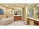 Elegant bathroom with double vanities, soaker tub, and vanity area at 990 Blvd Of The Arts # 1203, Sarasota, FL 34236