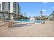 Large pool with a deck area featuring tables and chairs and a tall building surrounded by palm trees at 1050 Longboat Club Rd # 704, Longboat Key, FL 34228