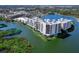 Aerial view of condo building with water views and mature trees at 10520 Boardwalk Loop # 205, Lakewood Ranch, FL 34202