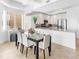 Bright dining area with a modern chandelier, table, and seating plus an open view of the modern kitchen at 10520 Boardwalk Loop # 205, Lakewood Ranch, FL 34202