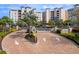 Elegant brick-paved entrance with lush landscaping leads to waterfront condos, offering a grand arrival experience at 10520 Boardwalk Loop # 205, Lakewood Ranch, FL 34202