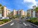 Stunning condo exterior featuring multiple balconies, lush greenery, and ample parking for residents and guests at 10520 Boardwalk Loop # 205, Lakewood Ranch, FL 34202