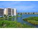 Exterior view of a condo building showcasing multiple balconies and lush landscaping along the water at 10520 Boardwalk Loop # 205, Lakewood Ranch, FL 34202
