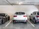 A secure garage featuring three parked luxury cars, offering convenient and protected parking at 10520 Boardwalk Loop # 205, Lakewood Ranch, FL 34202