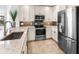 Well-lit kitchen features stainless steel appliances, granite counters, and modern white cabinetry at 10520 Boardwalk Loop # 205, Lakewood Ranch, FL 34202
