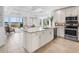 Bright open kitchen featuring stainless appliances, granite counters, and an open floorplan to the living room at 10520 Boardwalk Loop # 205, Lakewood Ranch, FL 34202