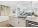 Well-lit kitchen with stainless appliances, ample granite counters, and an open floorplan to the living room at 10520 Boardwalk Loop # 205, Lakewood Ranch, FL 34202